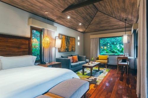 a bedroom with a bed and a living room at El Silencio Lodge & Spa Costa Rica in Toro Amarillo