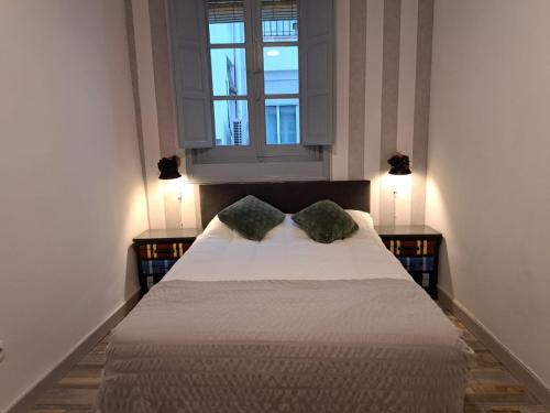 um quarto com uma cama com duas almofadas e uma janela em Chueca Modern Apartment em Madri