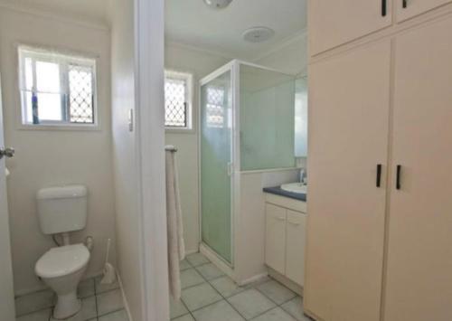 a white bathroom with a toilet and a sink at Island Villas - Lady Elliott - Unit 2 in Bundaberg