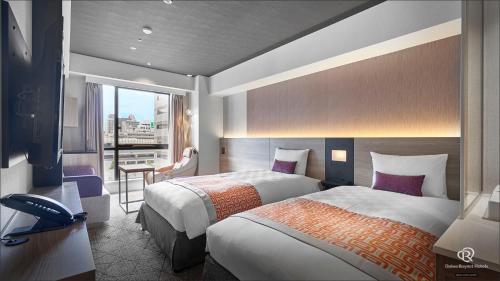 a hotel room with two beds and a balcony at Daiwa Roynet Hotel Osaka Sakaisuji Honmachi PREMIER in Osaka