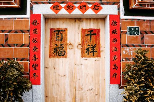 eine Holztür mit orientalischen Schildern darauf in der Unterkunft 拾穗 Ten again in Jinsha