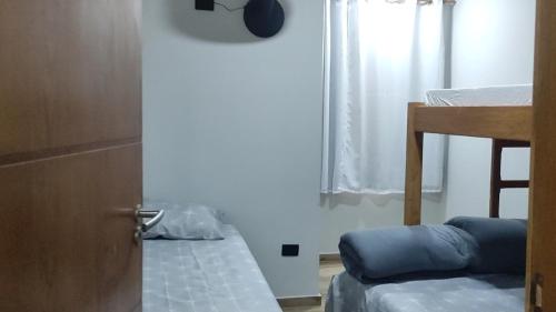 um quarto com uma porta com uma cama e uma janela em kitnets Porto Marujo em Paranaguá