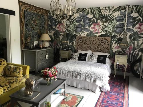 1 dormitorio con cama y pared de flores en A la guiniere, en Couëron