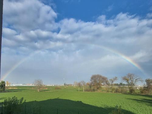 un arco iris en el cielo sobre un campo verde en Royal Suite Parma con Piscine Calda e Fredda en Parma