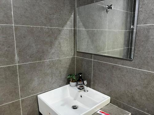 a bathroom with a sink and a mirror at Freesia Haus in Kota Bharu