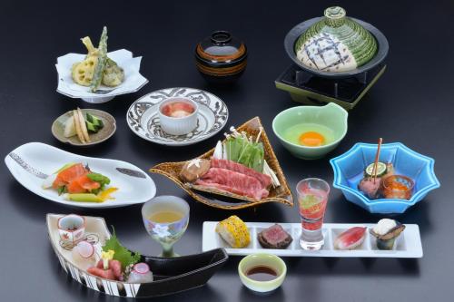 una mesa cubierta con platos de comida y bebida en Yura No Yado Seifuen en Achi