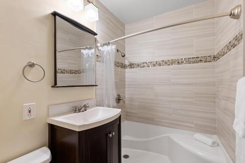 a white bathroom with a sink and a shower at Pacific Oasis - Large Patio, Parking & Walk to Beach in San Diego