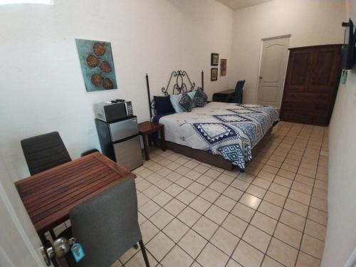 a bedroom with a bed and a tiled floor at Tres Migueles, estudio Anna, cerca de la marina, zona turistica y playa in Cabo San Lucas