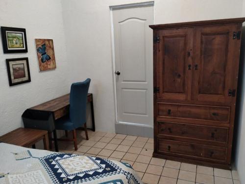 a bedroom with a bed and a dresser and a desk at Tres Migueles, estudio Anna, cerca de la marina, zona turistica y playa in Cabo San Lucas