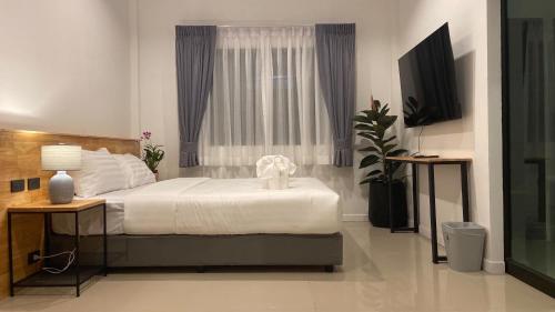 a bedroom with a large bed and a window at B House Phuket @Chalong in Chalong 