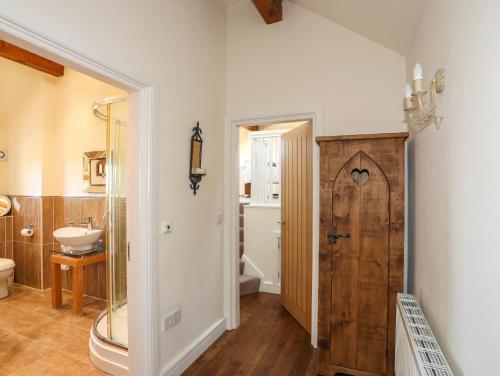 a bathroom with a shower and a toilet and a sink at Cosy Barn in Dwyran