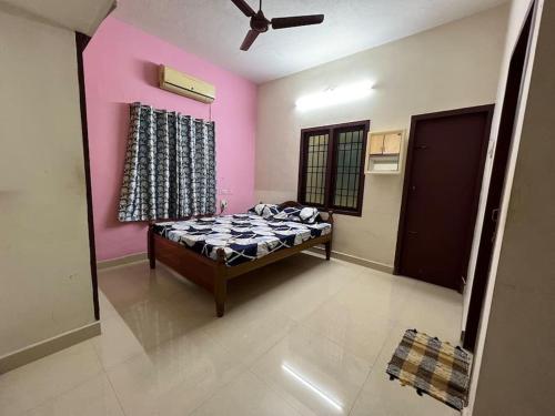 um quarto com uma cama num quarto com cor-de-rosa em The best enclave em Chennai