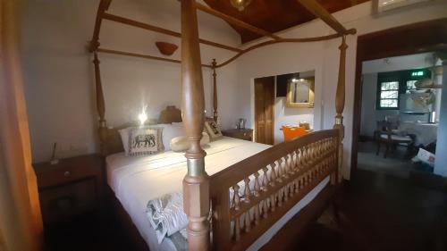 a canopy bed in a bedroom with a dining room at Vintekta Cottage in Weligama