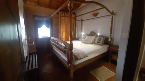 a bedroom with a canopy bed and a window at Vintekta Cottage in Weligama