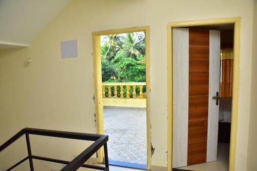 an open door leading to a patio with a porch at Field Stone -3 BHK duplex villa in Talaulim