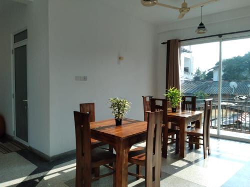 comedor con mesa de madera y sillas en Nethu villa, en Galle