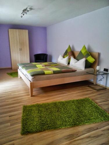 a bedroom with a large bed with green pillows at Ferienwohnung Zenzen in Adenau