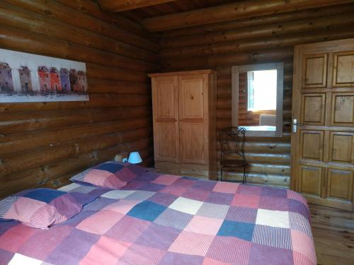 1 dormitorio con 1 cama en una cabaña de madera en CHALET DE L'OURS, en Saint-Pierre-dels-Forcats