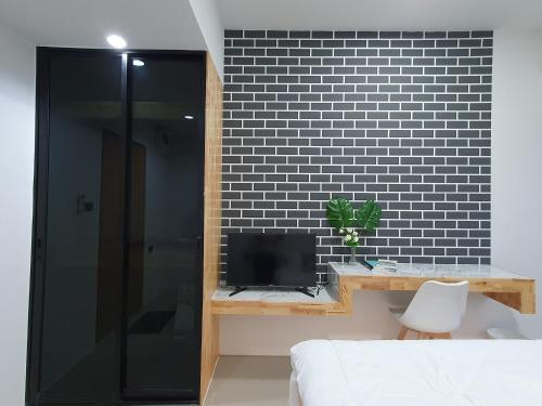 a bedroom with a bed and a tv and a black wall at Irich residence South Samrong 6 Kms BTS-Pu Chao in Samut Prakan