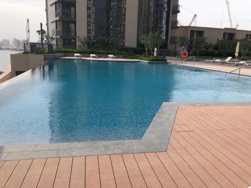 una gran piscina al lado de un edificio en BJ's luxury Burj and Creek View 2 BR Apartment en Dubái