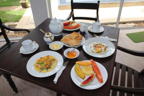 a table with plates of breakfast food on it at PRANA Beach Hotel Hikkaduwa in Hikkaduwa