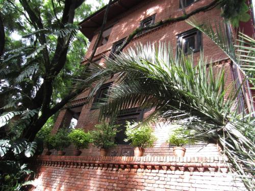 a brick building with potted plants on it at Vajra Hotel in Kathmandu