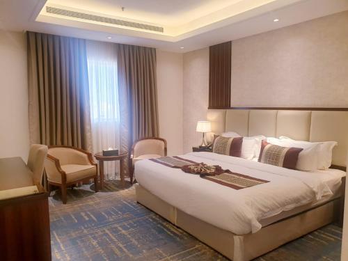 una habitación de hotel con una cama grande y una silla en لابرادوريت, en Yeda
