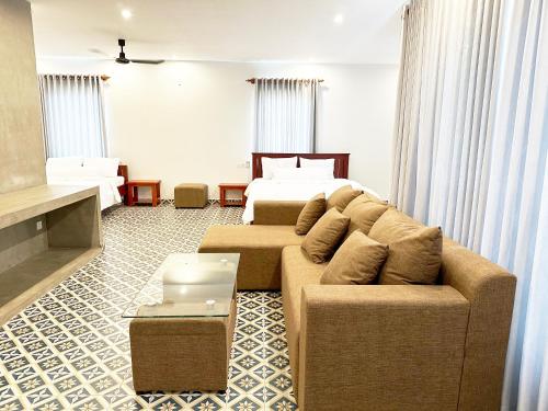 a living room with a couch and a bed at Eco Inn in Phumĭ Réach Born