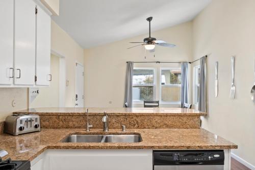 uma cozinha com um lavatório e uma janela em Pacific Paradise - Large Patio, Hot Tub, Short Walk to Beach, & Parking em San Diego