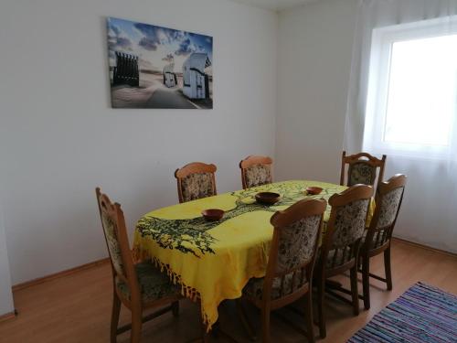 uma mesa de jantar e cadeiras com uma toalha de mesa amarela em Monteurwohnung App. 10 em Pirmasens