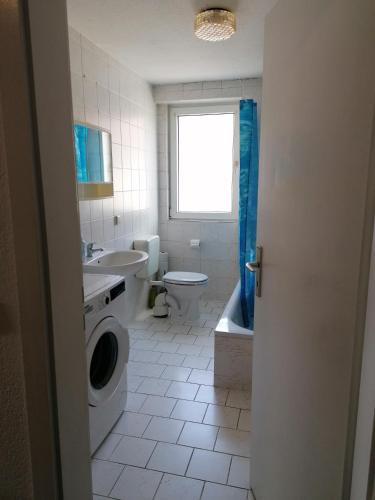 uma casa de banho com um lavatório e uma máquina de lavar roupa em Monteurwohnung App. 10 em Pirmasens