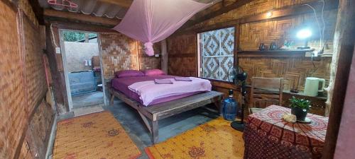 ein Schlafzimmer mit einem Bett in einem Holzzimmer in der Unterkunft Little Beach Garden in Ban Ai Dao