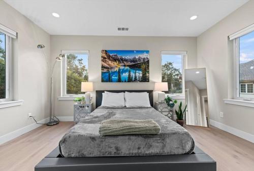a bedroom with a large bed and two windows at The Garden House--5 bedrooms, sleeps 12 in San Jose