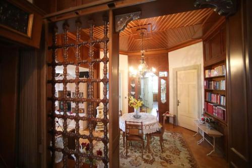 a dining room with a table and a chandelier at Κομψό & πολυτελές νεοκλασικό στο κέντρο της πόλης in Kastoria