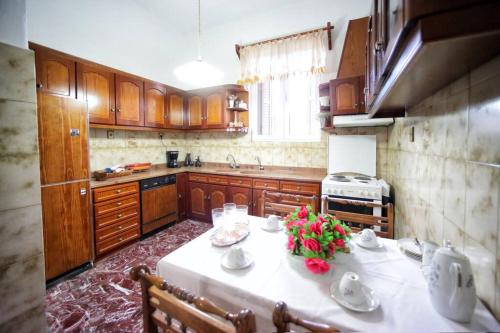 a kitchen with a table with flowers on it at Κομψό & πολυτελές νεοκλασικό στο κέντρο της πόλης in Kastoria