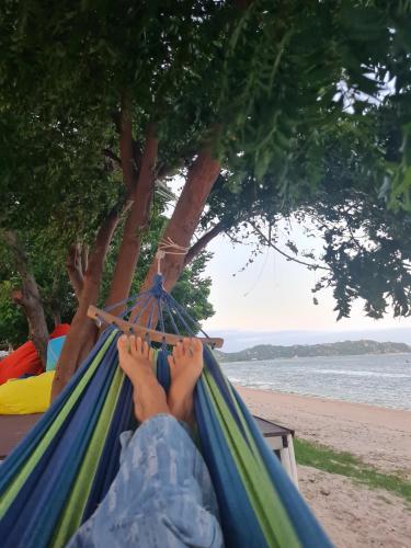 a person laying in a hammock on the beach at Myhoa Lagoon - Kiting Town in Phan Rang