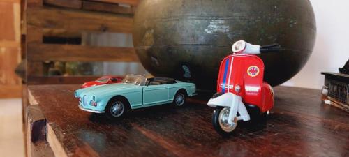 a toy car and a scooter parked next to a vase at Ayubowan Holiday Home in Kandy