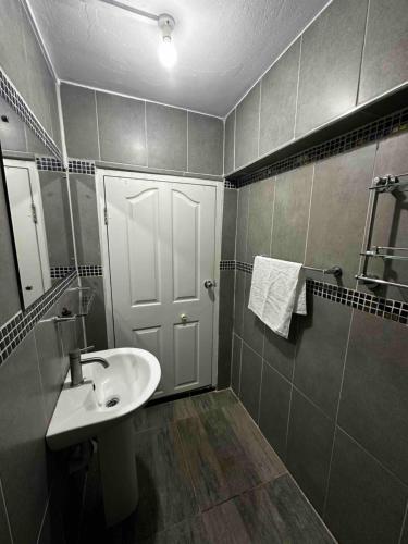 a bathroom with a sink and a white door at Home Away Comfort stay in Suva