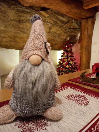 a stuffed animal sitting on a table next to a christmas tree at Bed & Breakfast La Crotta in Pont-Saint-Martin