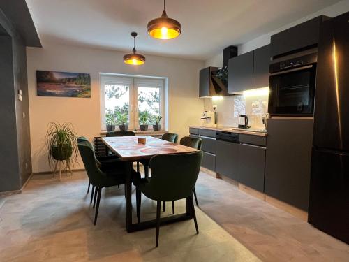 a kitchen and dining room with a table and chairs at Chata OXY in Ždiar