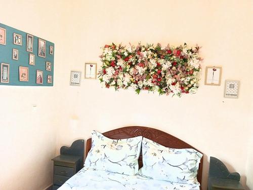 a wreath hanging on a wall above a bed at Studio meublé Yaoundé Ekounou in Yaoundé