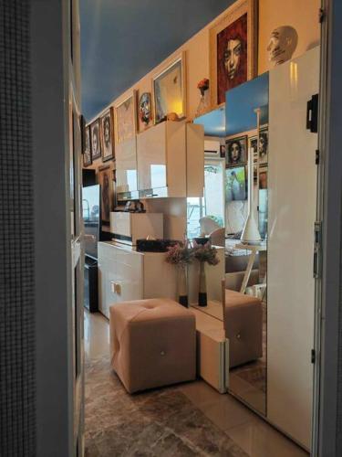 a kitchen with white cabinets and a table with a stool at Art Under the Clouds 32nd floor sea view SuperHost in North Pattaya