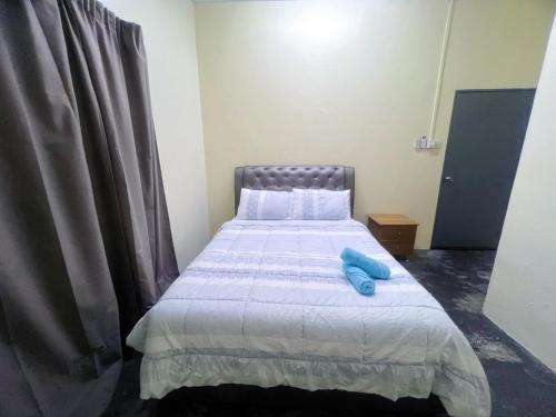 een slaapkamer met een bed met een blauw voorwerp erop bij Leisure Homestay in Kampong Peruntun
