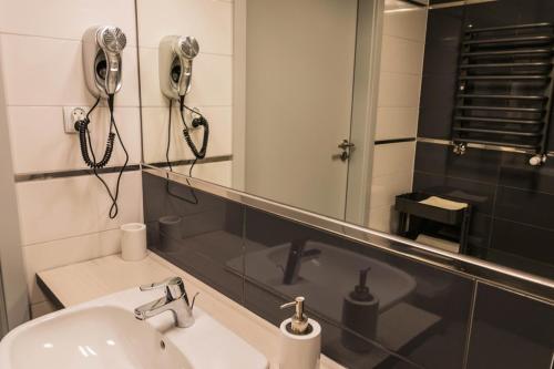 un bagno con lavandino e specchio di Czarna Góra Resort Apartament na Skarpie a Sienna