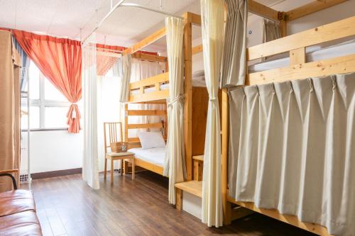 - une chambre avec 2 lits superposés et un canapé dans l'établissement Almas Guest House(アルマス）, à Nagasaki