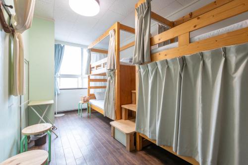 a room with two bunk beds and a table at Almas Guest House(アルマス） in Nagasaki