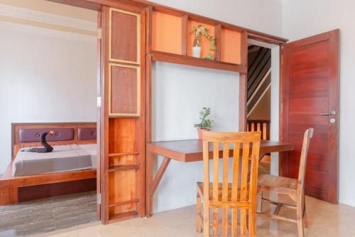 a room with a desk and a bed and a chair at Pigeon Mandala Apartments & Resto in Nusa Dua