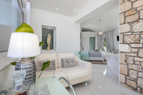 a living room with a white couch and a stone wall at Dion Villa Zakynthos Greece in Agios Nikolaos