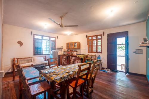 una sala da pranzo con un lungo tavolo e sedie di Kiungani Lodge a Jambiani