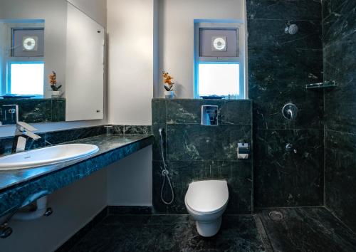 a bathroom with a toilet and a shower and a sink at Nest By Rivido Apart Hotel, Bannerghatta road in Bangalore